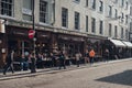People sitting at the outdoor tables of Cafe Boheme in Soho, London, UK