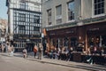 People sitting at the outdoor tables of Cafe Boheme in Soho, London, UK