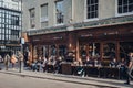 People sitting at the outdoor tables of Cafe Boheme in Soho, London, UK