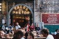 People sitting at the outdoor tables of El Pastor Tacos restaurant in Borough Market, London, UK
