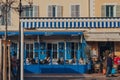 People sitting at the outdoor tables of Le Safari restaurant on Cours Saleya street in Nice, France