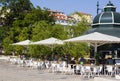 Pretty open cafÃÂ© with white parasols around traditional metal pavillon at Cais do SodrÃÂ© district in Lisbon, Portugal. Royalty Free Stock Photo