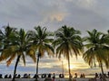 people are sitting relaxing on the beach enjoying the sunset