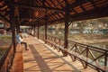 People sitting and relaxing on covered pedestrian bridge at hot day of historical city