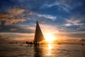 People sitting on sailboat at ocean and looking sunset Royalty Free Stock Photo