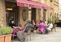 People sitting in a small cafe outside in the medieval town of Montepulciano