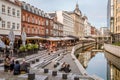 People sitting on a square at Aarhus canal in the center of the city