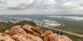 People sitting on the stones on the mountain with Gaborone city