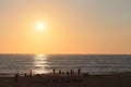 People sitting watching sunset on the beach Seignosse France, twilight, sparkle, golden sky silver water background. Royalty Free Stock Photo