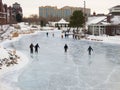 People skate at early evening on a frozen lake Royalty Free Stock Photo