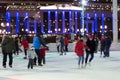 People skate in the evening on a city skating rink.