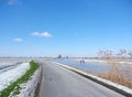 people skate on the ice on canal in alblasserwaard under blue sky Royalty Free Stock Photo