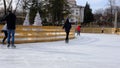 People skating during the day, having fun and studying on ice rink near Drama Theater Mariupol, Ukraine. Several days