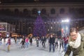 People Skating on the Ice Rink in Bryant Park in New York on Christmas Day. Impressive Christmas Tree in the Background