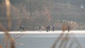 People skating and walking on the frozen lake, fall season