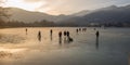 People skating and walking on the frozen lake, fall season