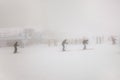 People skiing on extreme weather with fog and zero visibility