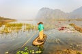 People with small boat on Van Long pond, Ninh Binh province, Vietnam