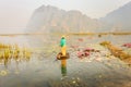 People with small boat on Van Long pond, Ninh Binh province, Vietnam