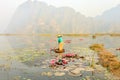 People with small boat on Van Long pond, Ninh Binh province, Vietnam