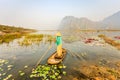 People with small boat on Van Long pond, Ninh Binh province, Vietnam