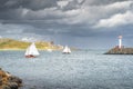 People on a small sailboats exiting Howth marina, with Irelands Eye island in the background