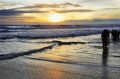 People soaking them in Kovalam beach at sunset, Kerala, India