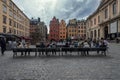 People socializing on park benches in a bustling urban area in Stockholm, Sweden.