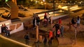 People spend time in the modern park in the evening. Stock footage. Families walking in the city park with unusual