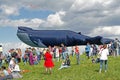 People stand against the background of a huge whale kite at the kite festival in the Park Tsaritsyno in Moscow