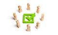 People stand in a circle and look at the green check mark in the box. election, poll or referendum. Poll people. Voters Royalty Free Stock Photo