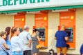 people stand in line at Sberbank ATM for various financial transactions. The text in Russian: Sberbank, ATM, cash and other servic