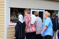 People stand in a queue at the kiosk for the sale of vegetables