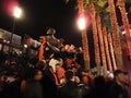 People stand on top Willie Mays statue at night