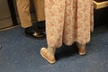 People stand in the train. look at their shoes. girl in a long pink dress and pink sneakers