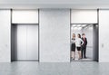 People standing in elevator, the second one is closed