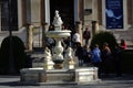 People standing by a fountain in a sunny morning in Seville