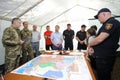 People standing in front of a table with maps. The headquarter of a firefighters, planning