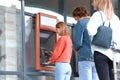 People standing in queue to cash machine