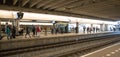 People standing on railway station covered underground platforms waiting for trains to arrive Royalty Free Stock Photo