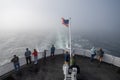 People on stern of ferry in dense fog off Port Angeles, Washington.