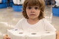 People are stocking up toilet paper for home quarantine from crownavirus. Cute child holds many rolls of toilet paper Royalty Free Stock Photo