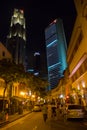 People In The Street And High Skyscrapers Buildings In Singapore At Night.