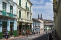 People in a street in the historic center of the city of Quito, in Ecuador, with the Basilica of the National Vow on the backgroun Royalty Free Stock Photo