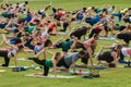 People Stretch Right Leg In Unison At Outdoor Yoga Class