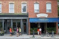 People stroll on Queen Street East in front of local restaurants,