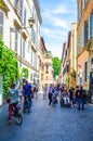 people are strollin through narrow street of trastevere district in italian capital rome, which ic local center of