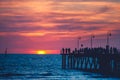 People strolling along the Glenelg Jetty at sunset