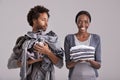 People, studio and pile of clothes in hand for laundry day, wash and couple cleaning together. Woman, happy and neat Royalty Free Stock Photo