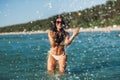 woman in bikini splashing sea water on beach Royalty Free Stock Photo